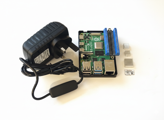 Raspberry Pi kit with power adapter, cables, and SD card on a white background